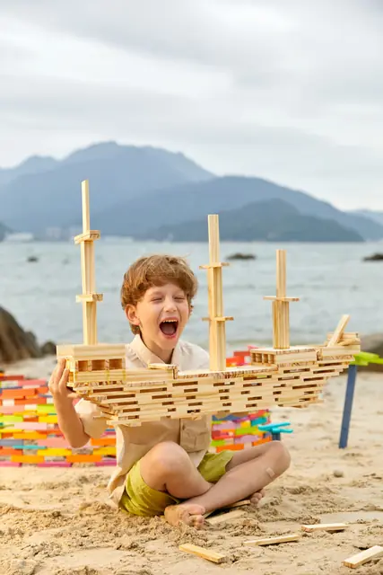 A child building with mideer wooden blocks by the sea