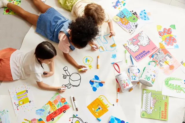 Children painting on a large mideer art roll