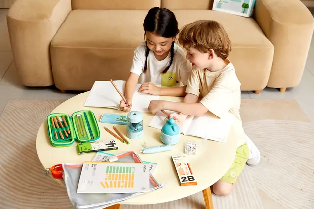 Two children using mideer school supplies at a table
