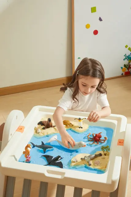 A child playing with mideer marine animal figures